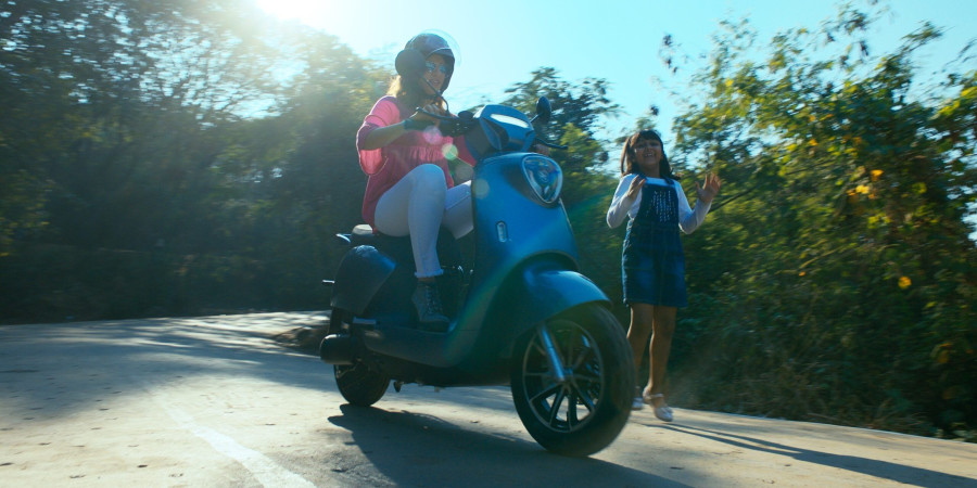 Femme conduisant un scooter sur une route