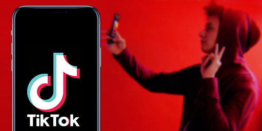 Logo de Tiktok et jeune homme utilisant un smartphone