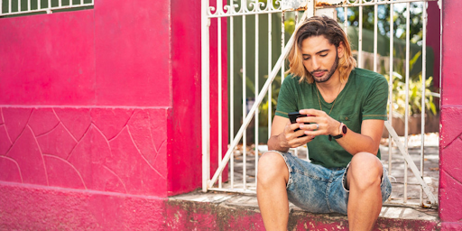 Un jeune homme de la communauté LGBTQ+ utilisant son smartphone