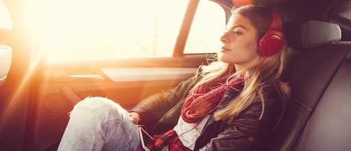 Une jeune fille en train d'écouter des podcasts en voiture