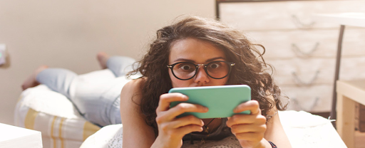 Une jeune femme connectée sur les réseaux sociaux depuis son smartphone