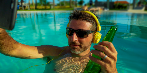 Un homme dans une piscine en train de se prendre en photo avec son smartphone