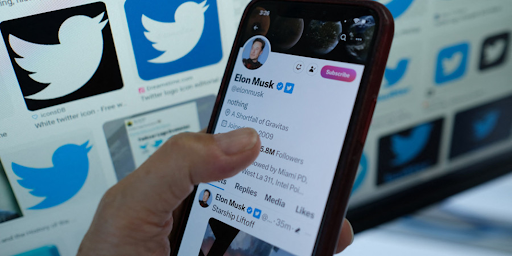 Une personne en train de regarder le profil d'Elon Musk sur son smartphone