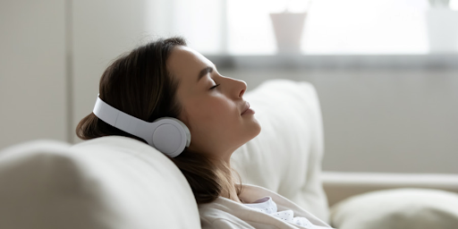 Une jeune femme en train d'écouter des contenus audio érotiques