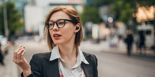 Une femme dans la rue utilisant des écouteurs sans fil pour écouter de la musique