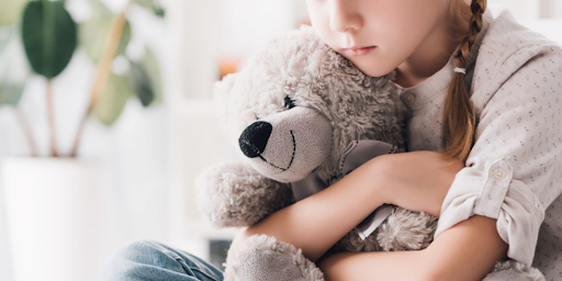 Un enfant serrant dans ses bras une peluche